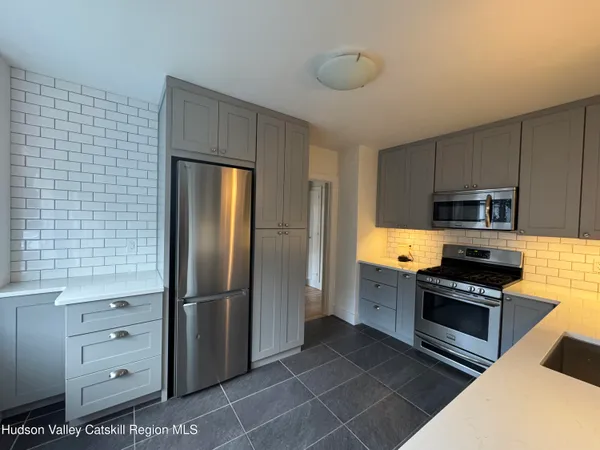 a kitchen with stainless steel appliances granite countertop a refrigerator and a stove