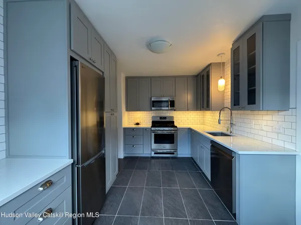 a large kitchen with a large counter top stainless steel appliances and cabinets