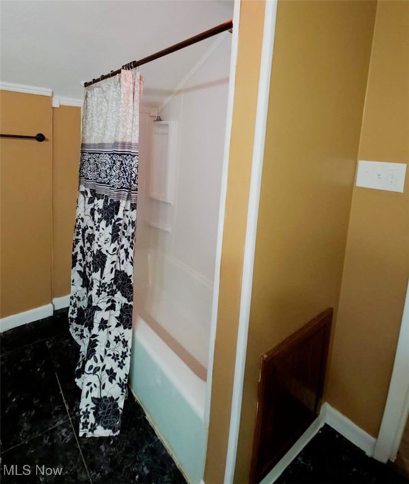 30 Medina Street Rittman, OH 44270 - Photo 15 of 28 Bathroom featuring shower / tub combo with curtain and dark tile patterned flooring