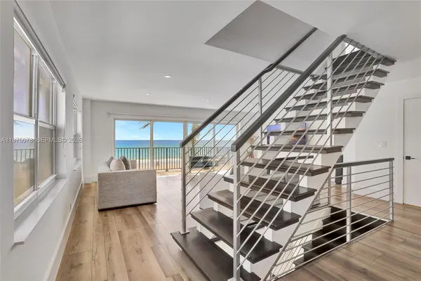 a kitchen with stainless steel appliances a dining table chairs and wooden floor