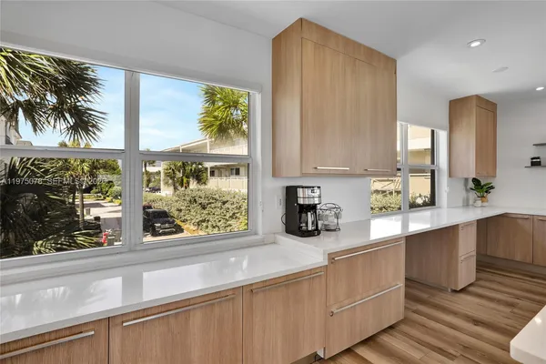 a large kitchen with stainless steel appliances a sink a stove and a window