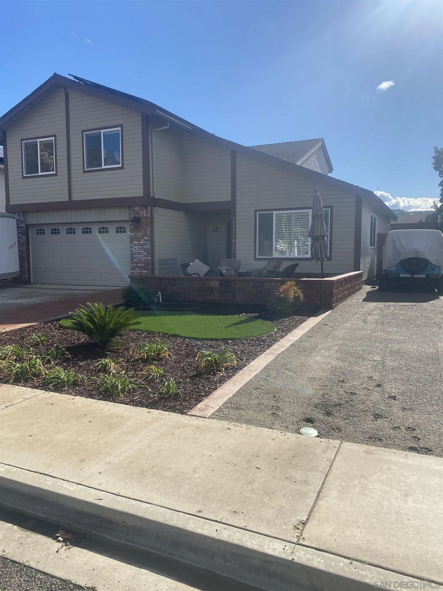 10991 Hillcreek Road Santee, CA 92071 - Photo 2 of 26 a front view of a house with a yard and garage