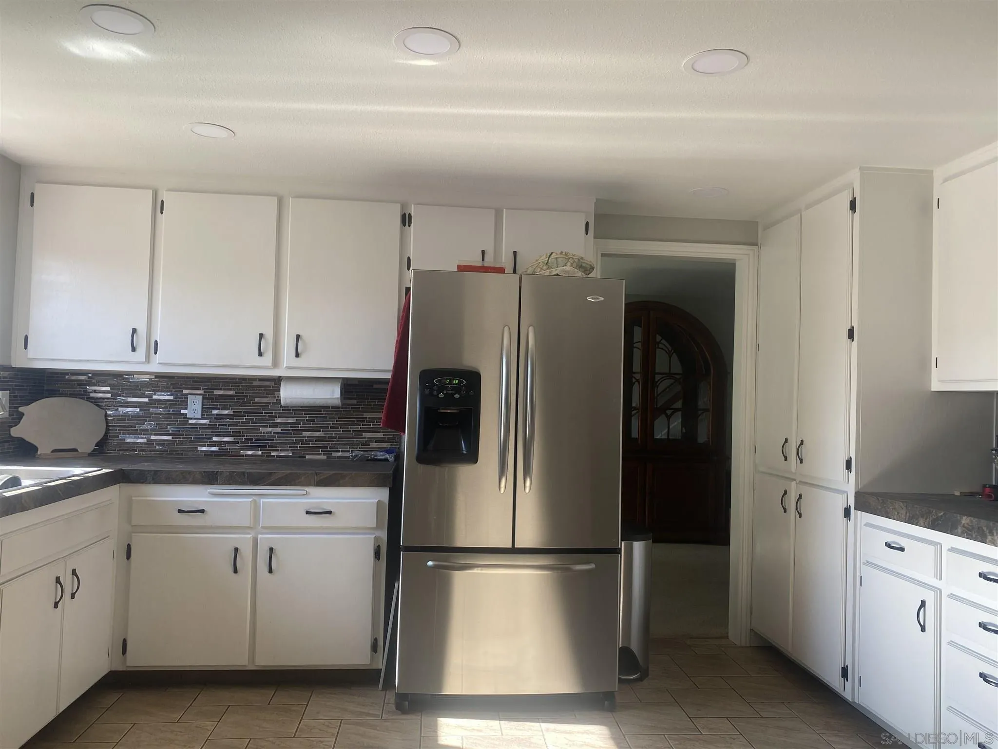 10991 Hillcreek Road Santee, CA 92071 - Photo 6 of 26 a kitchen with appliances a refrigerator a sink and cabinets