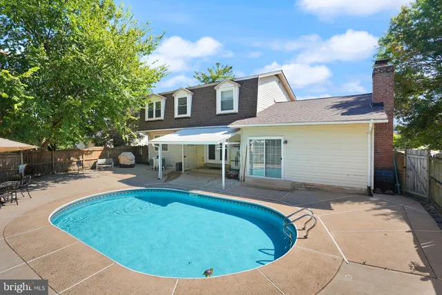 a view of a house with swimming pool and sitting area