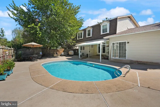 a view of backyard of house with wooden fence