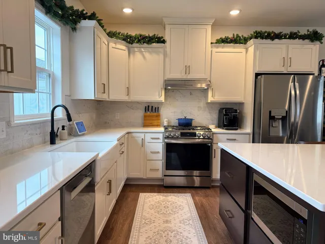 a kitchen with a sink a refrigerator and cabinets