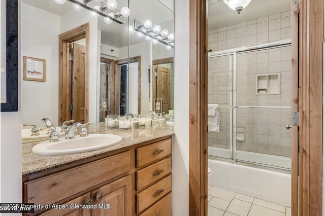 a bathroom with a double vanity sink mirror and shower
