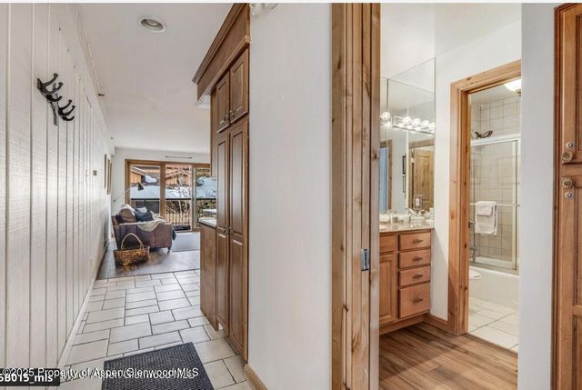 a view of a hallway with wooden floor and furniture