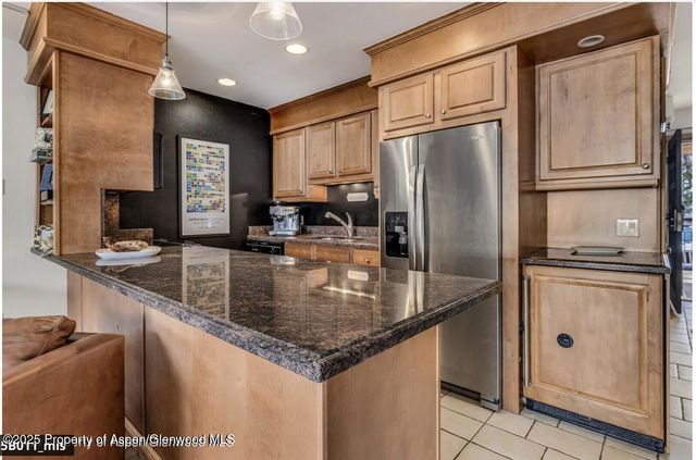 a kitchen with stainless steel appliances granite countertop a refrigerator a sink and a stove