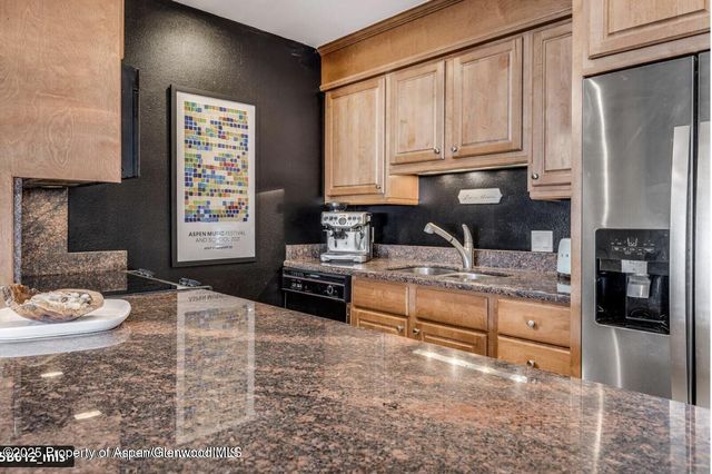 a kitchen with stainless steel appliances granite countertop a stove a sink and a refrigerator