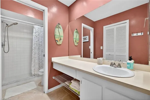 a bedroom with a bed and a dresser next to a window
