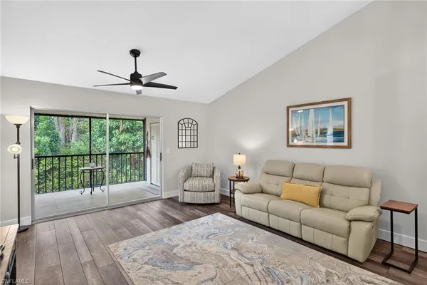a living room with furniture a dining table and a chandelier