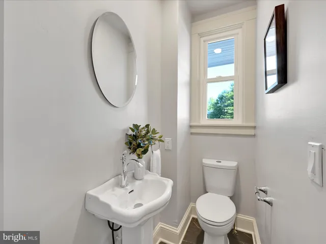 a bathroom with a toilet a sink and a mirror