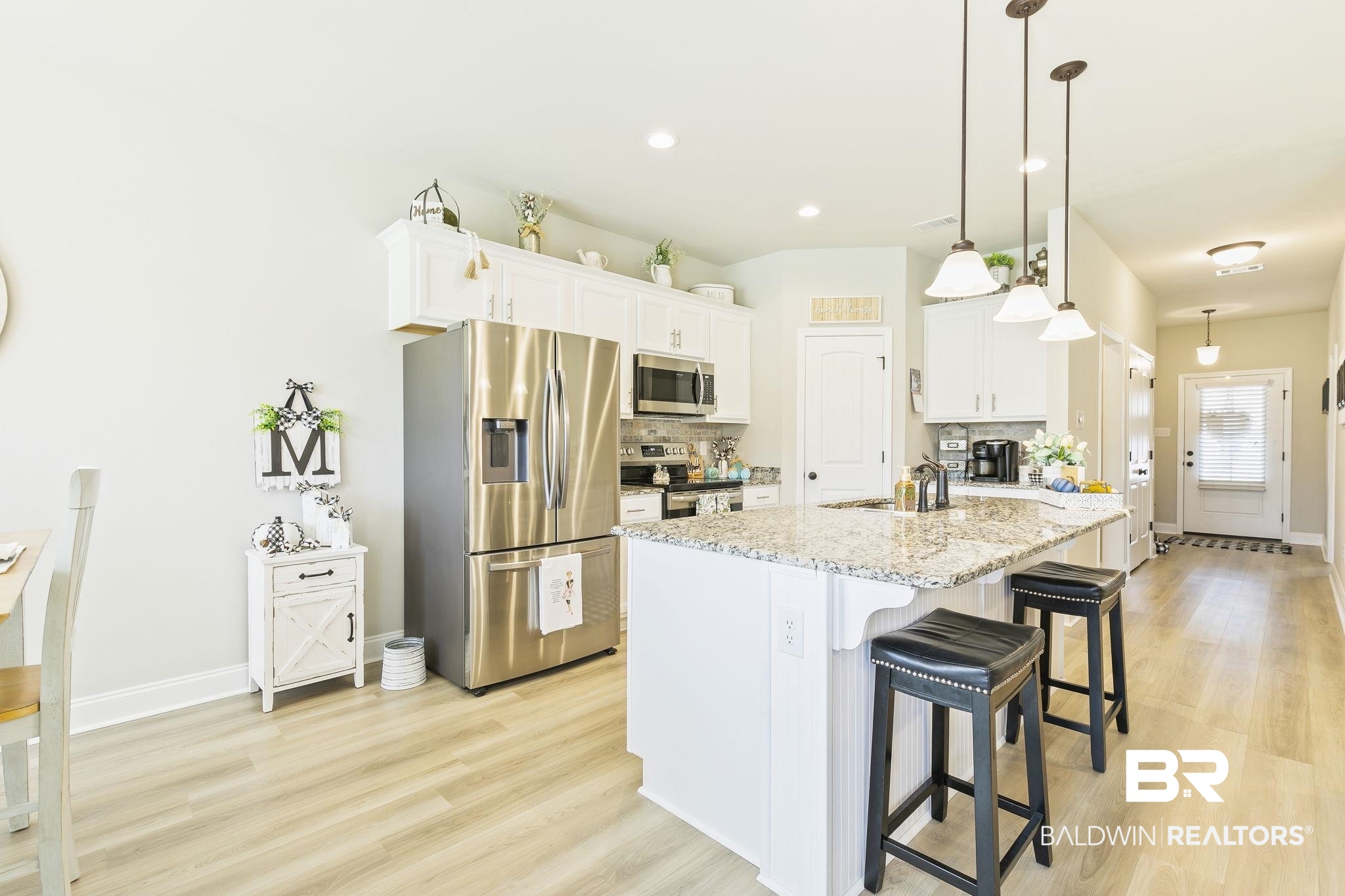 910 Gibson Court Foley, AL 36535 - Photo 22 of 66 Featuring stainless steel appliances, nice white cabinetry, tumbled marble tiled backsplash, and granite countertops. Light and open with pretty view of the backyard and lake.