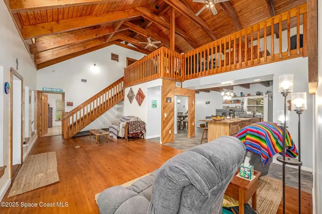 a living room with lots of furniture and paintings on the wall