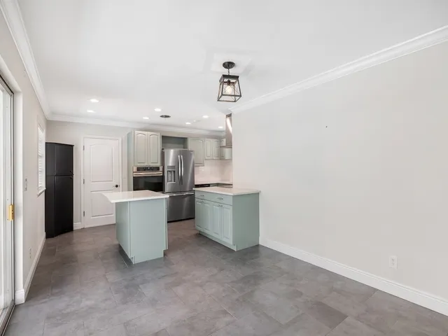 a view of open kitchen with a sink and refrigerator