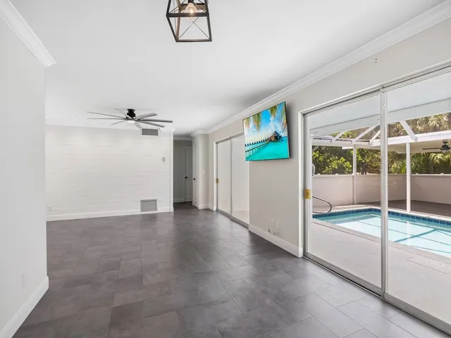 a view of an empty room and window ceiling fan