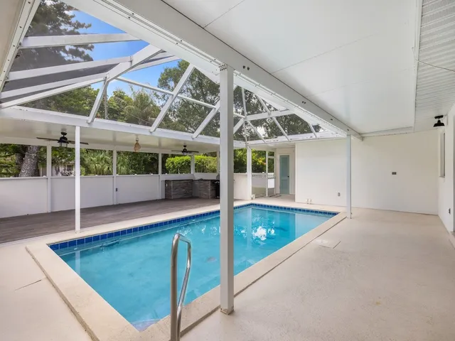 a view of an empty room with wooden floor and windows
