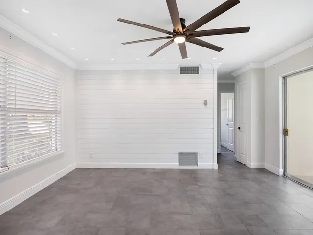 wooden floor in an empty room with a ceiling fan