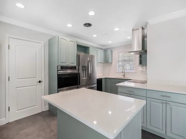 a large white kitchen with a sink stainless steel appliances and cabinets