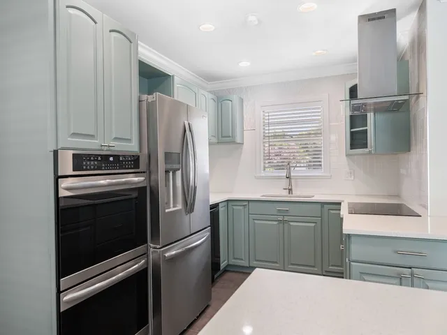 a kitchen with stainless steel appliances granite countertop a refrigerator sink and stove