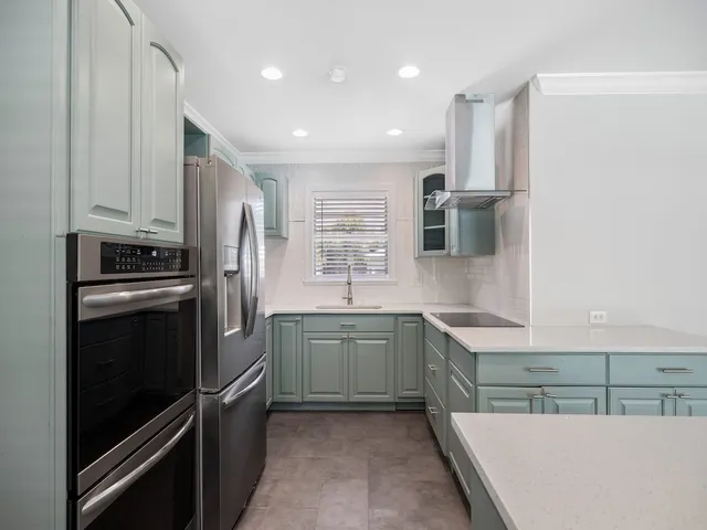 a kitchen with stainless steel appliances granite countertop a refrigerator and a sink