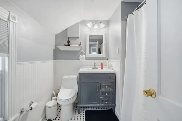 a bathroom with a sink toilet and mirror