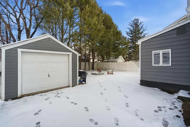 a front view of a house with a yard covered in snow