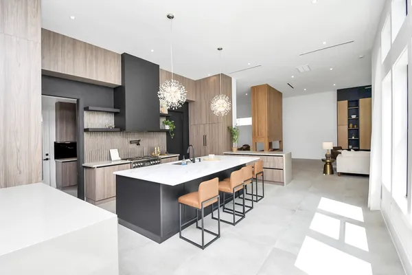 a large white kitchen with a sink and a large window