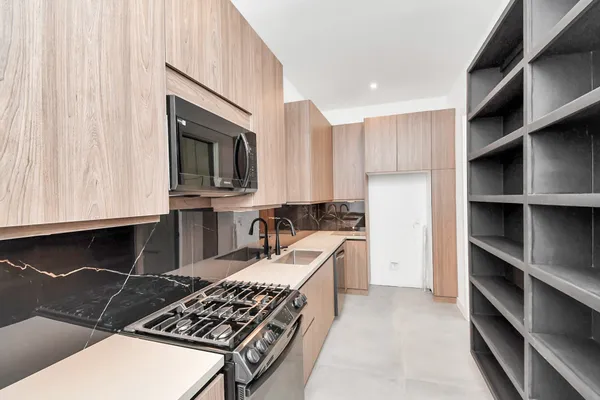 a kitchen with sink stove and refrigerator