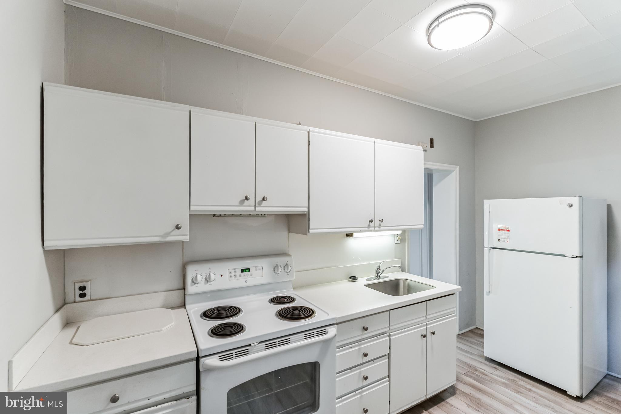 4483 Boone Street Philadelphia, PA 19128 - Photo 8 of 15 a kitchen with a refrigerator stove and white cabinets