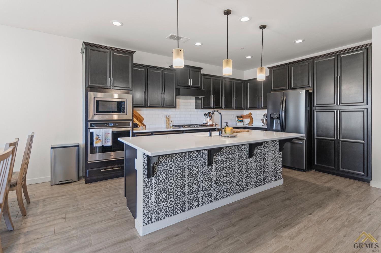 Undisclosed Address Bakersfield, CA 93314 - Photo 19 of 44 a kitchen with stainless steel appliances granite countertop a sink a stove and a wooden floors