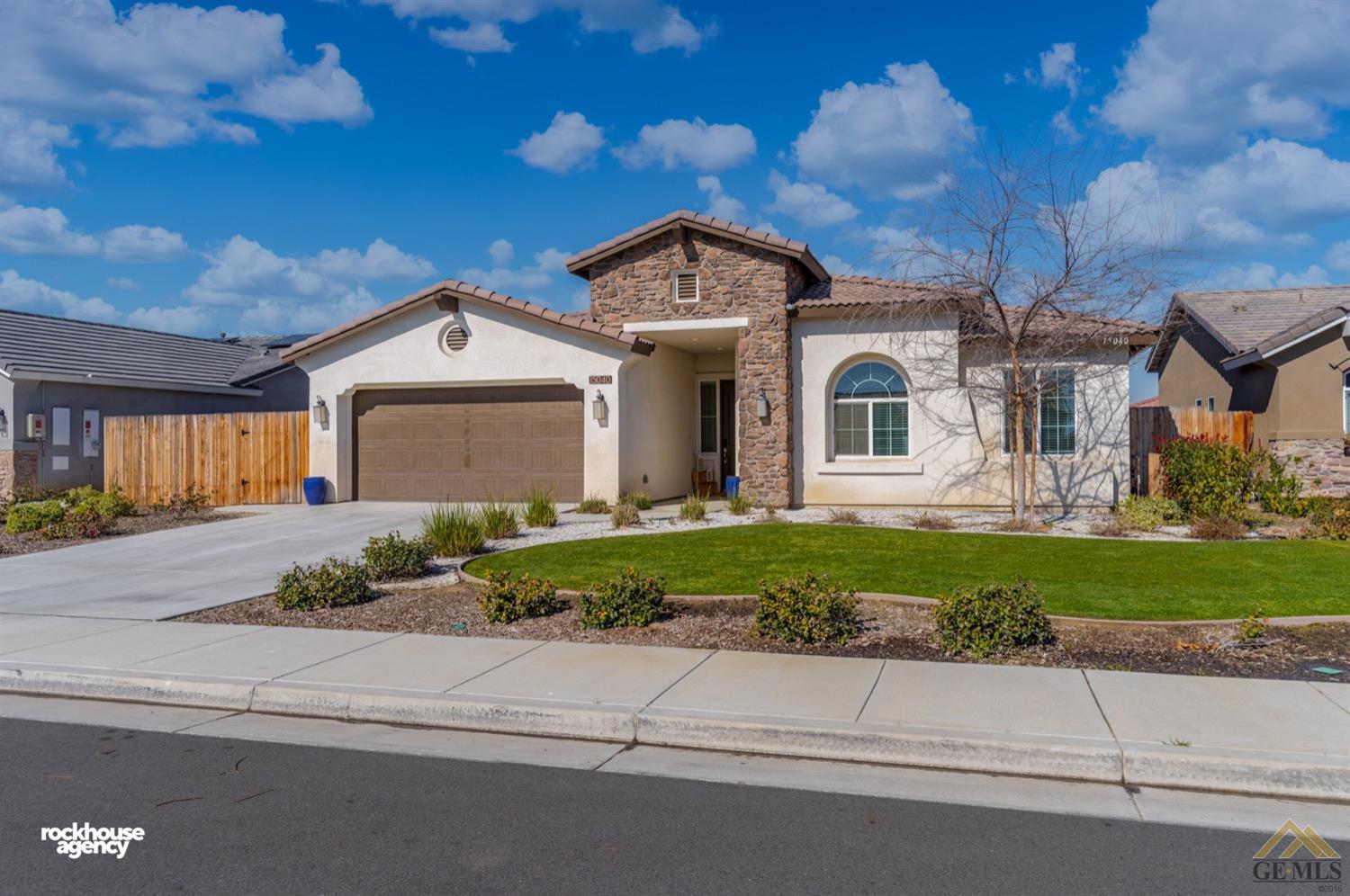 Undisclosed Address Bakersfield, CA 93314 - Photo 2 of 44 a front view of a house with a yard and a garage