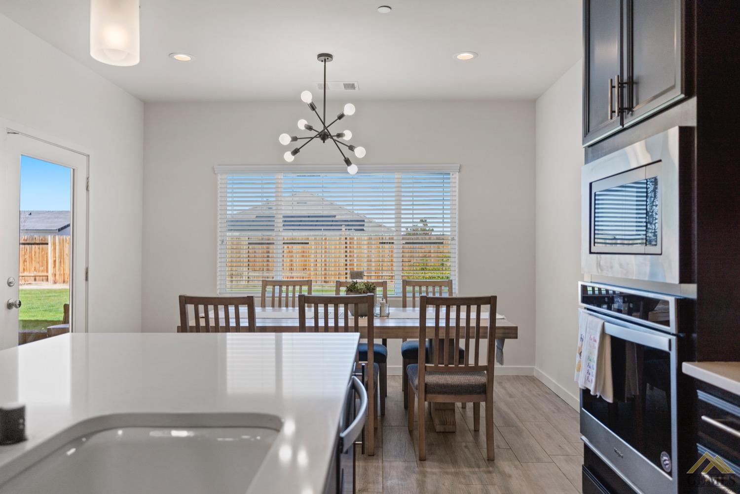 Undisclosed Address Bakersfield, CA 93314 - Photo 25 of 44 a view of a dining room with furniture wooden floor and chandelier