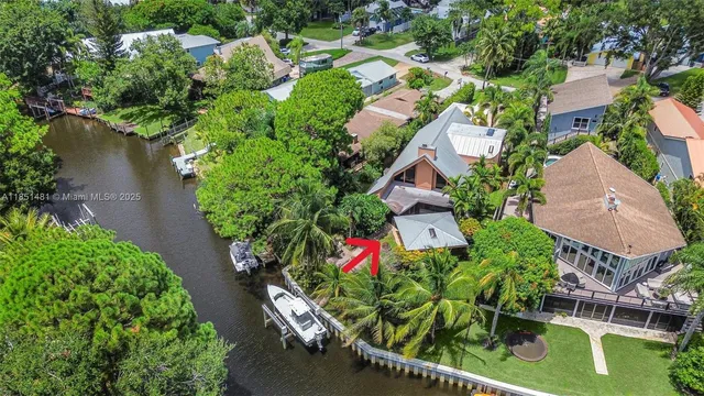 an aerial view of residential house with outdoor space and trees all around