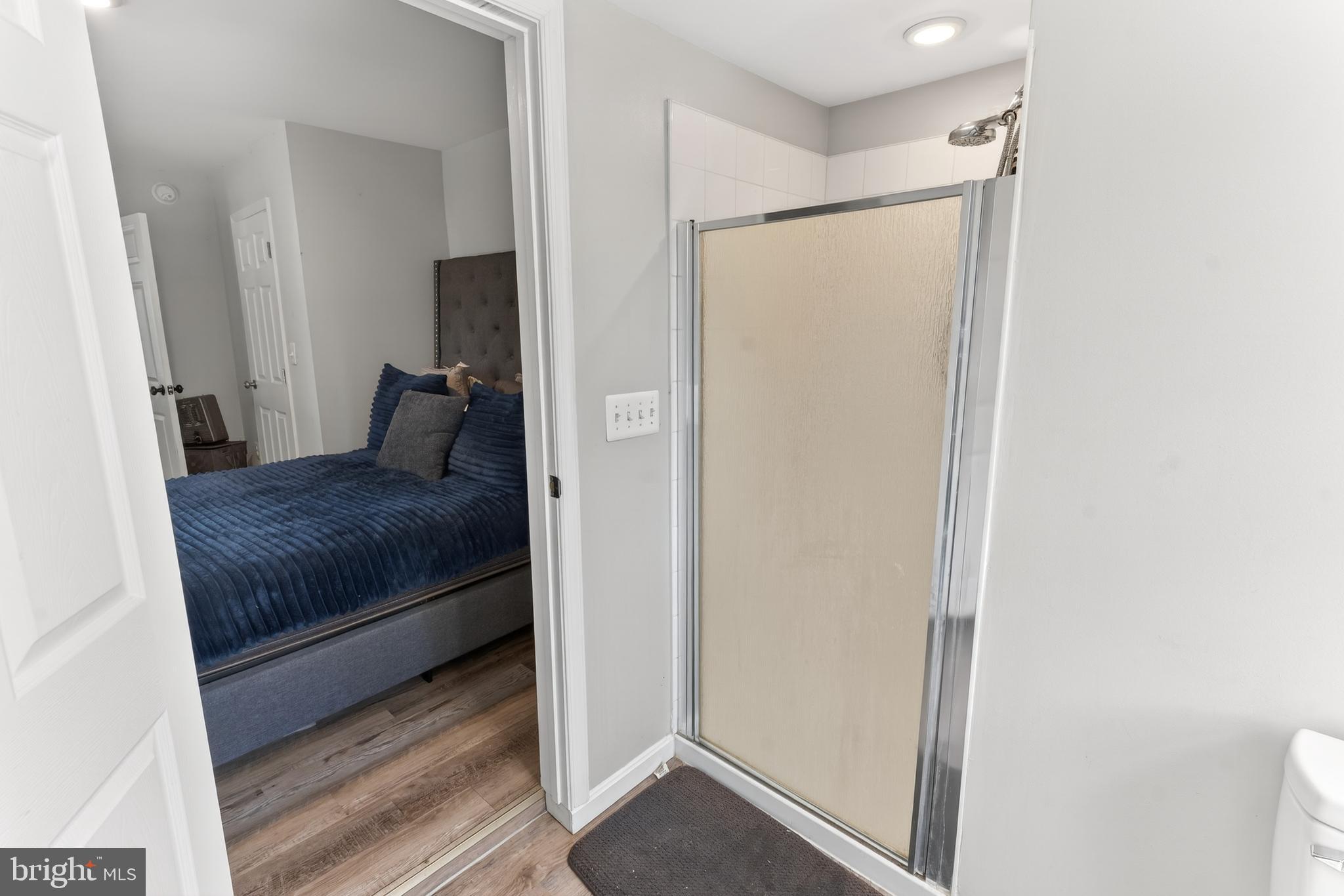 1002 West Main Street Salisbury, MD 21801 - Photo 13 of 31 a bedroom with a large bed and a glass door shower