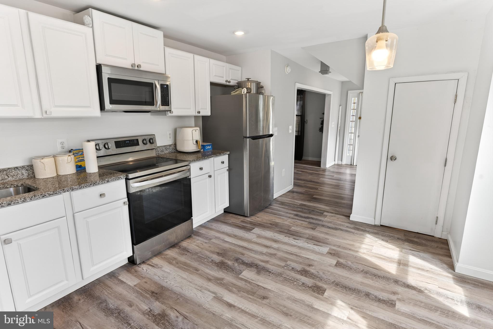 1002 West Main Street Salisbury, MD 21801 - Photo 17 of 31 a kitchen with stainless steel appliances granite countertop a refrigerator stove microwave and sink