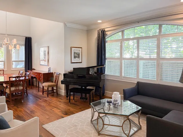 a living room with furniture kitchen view and a wooden floor