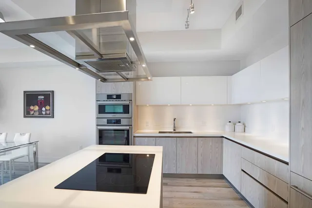 a kitchen with a sink a stove and cabinets
