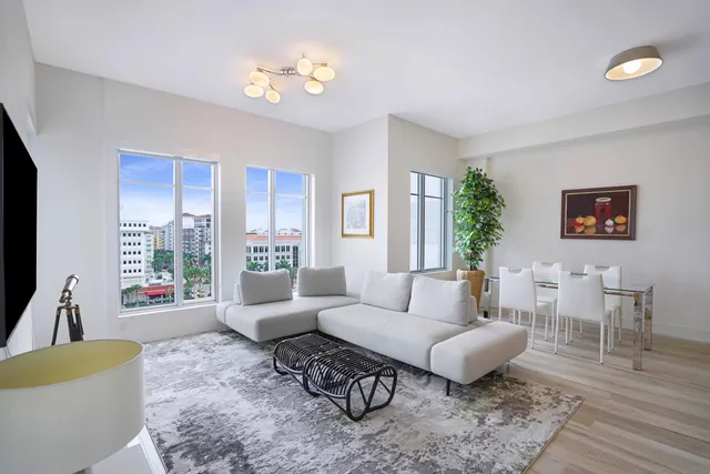 a living room with furniture potted plant and a large window