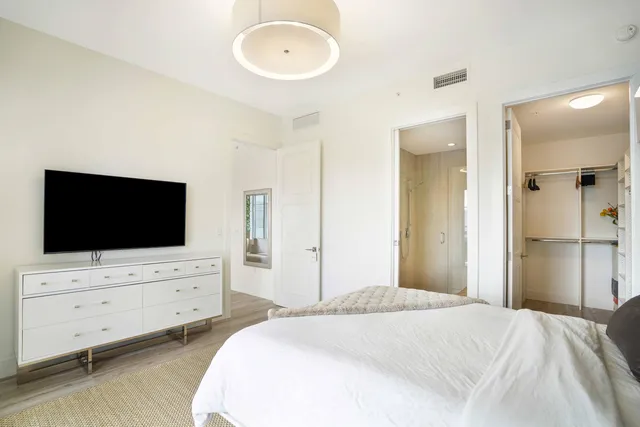 a bedroom with bed and flat screen tv