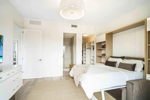 a bedroom with a bed and a large mirror