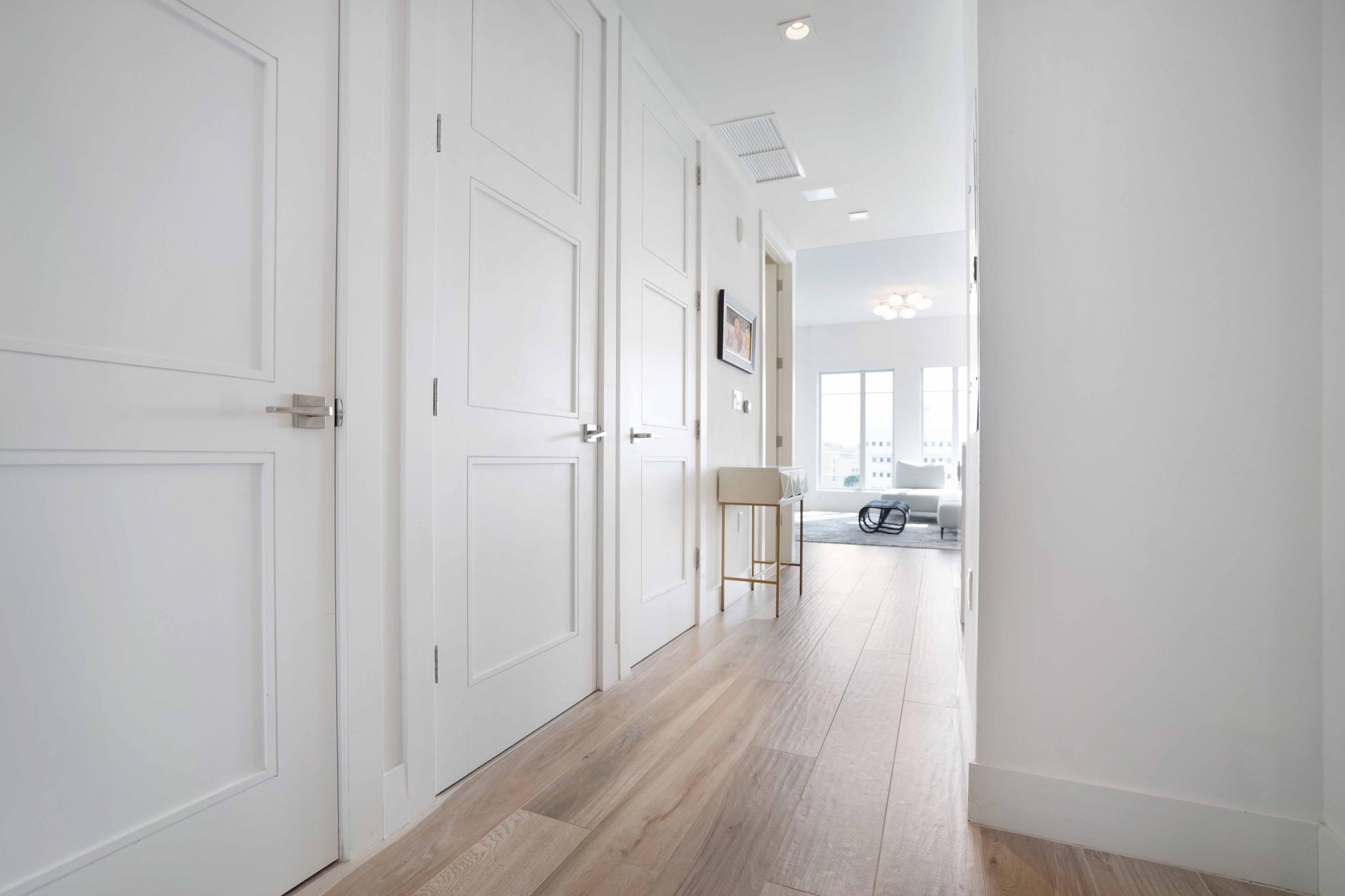 155 East Boca Raton Road, Unit 912 Boca Raton, FL 33432 - Photo 6 of 56 a view of a hallway with wooden floor a glass door and a bathroom