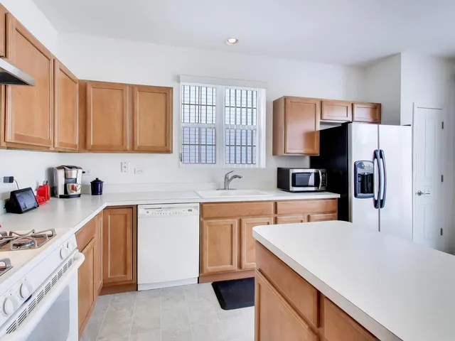 a kitchen with a white stove top oven sink and cabinets