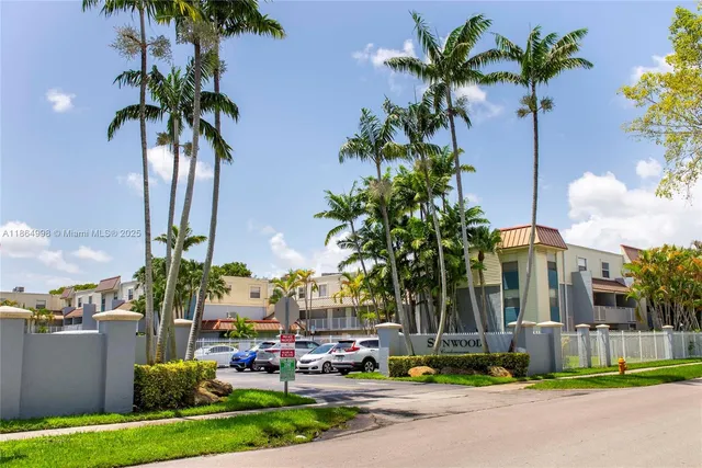 a front view of multi story residential apartment building with yard and sign board