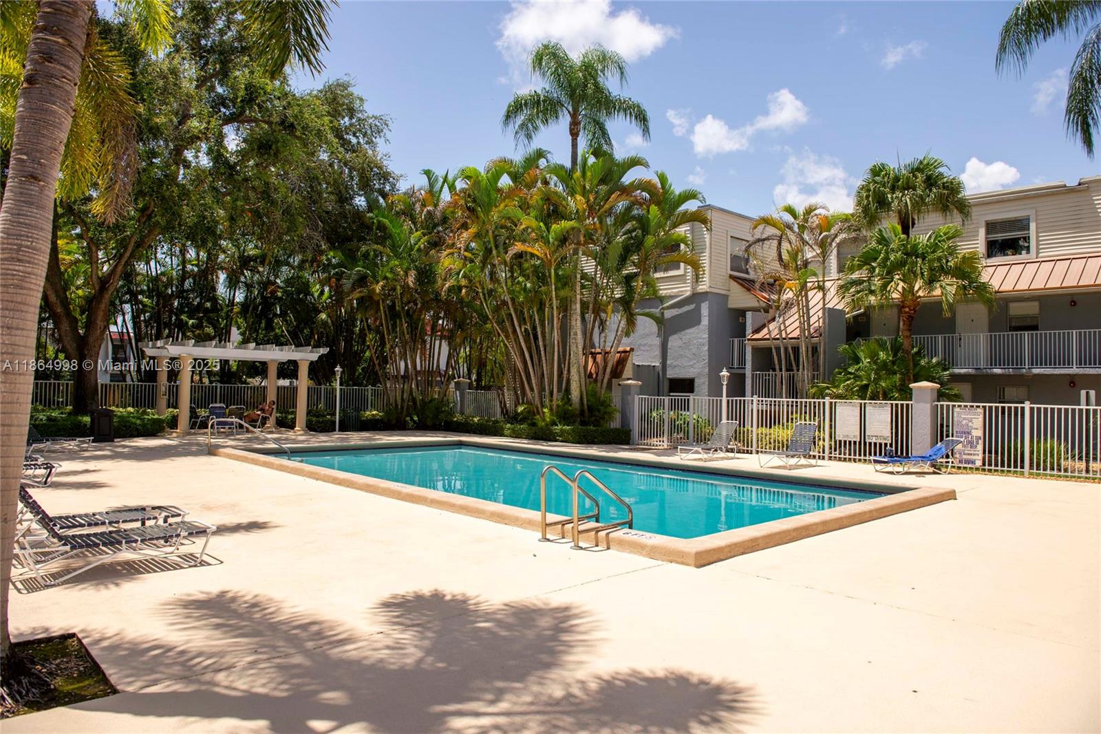 4600 Southwest 67th Avenue, Unit 237 Miami, FL 33155 - Photo 17 of 18 a view of a swimming pool with a lawn chairs next to a road