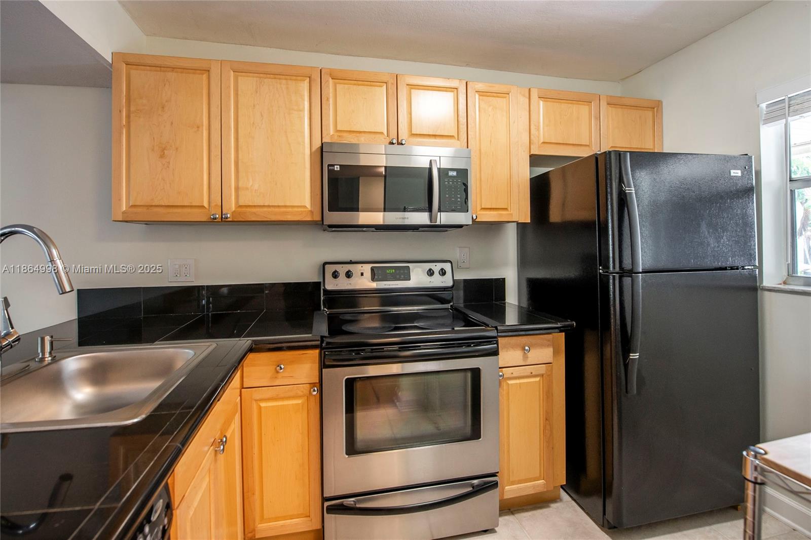 4600 Southwest 67th Avenue, Unit 237 Miami, FL 33155 - Photo 5 of 18 a kitchen with stainless steel appliances granite countertop a refrigerator a stove a sink and a microwave