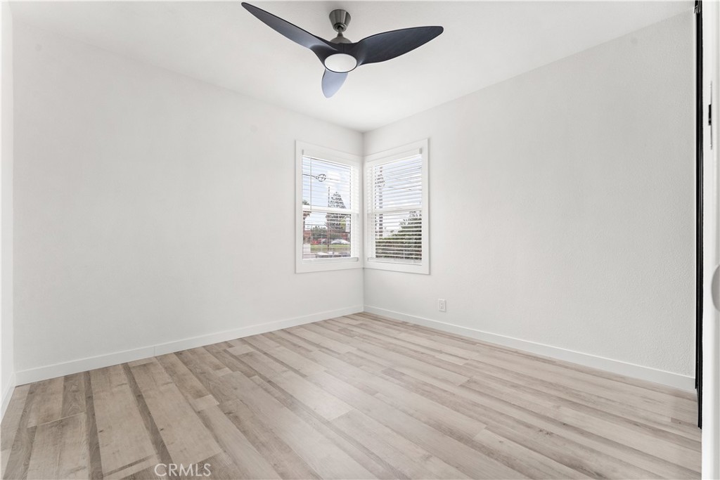 2234 South Standard Avenue Santa Ana, CA 92707 - Photo 11 of 30 an empty room with wooden floor ceiling fan and windows