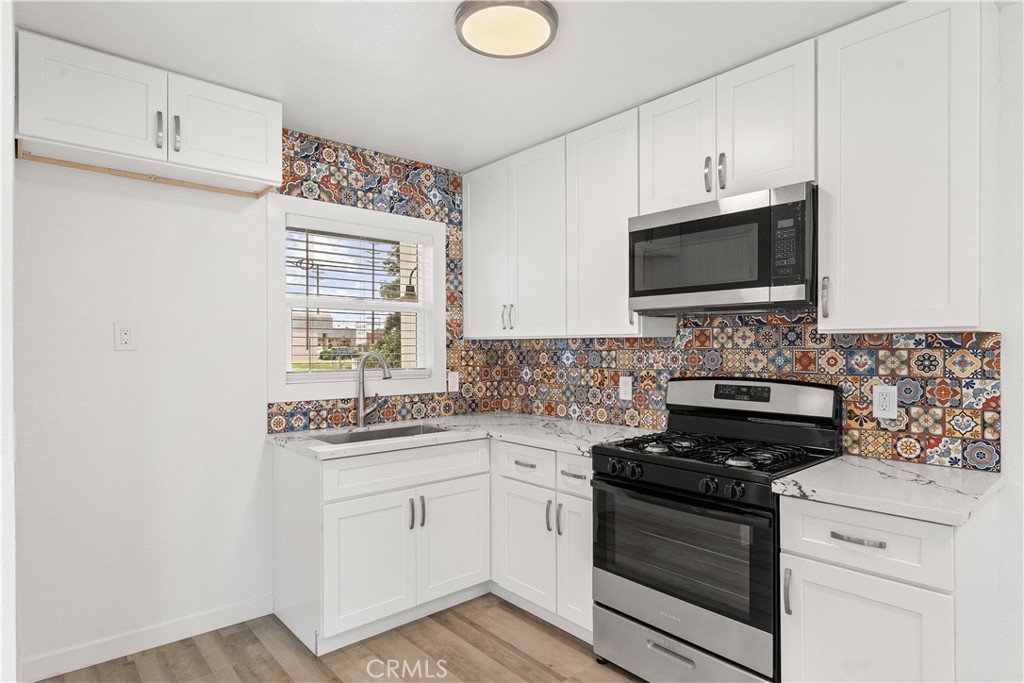 2234 South Standard Avenue Santa Ana, CA 92707 - Photo 22 of 30 a kitchen with stainless steel appliances white cabinets and a stove a oven with wooden floor