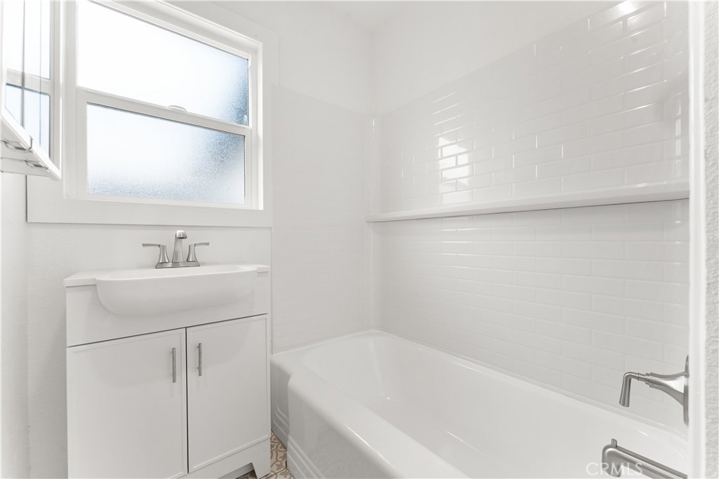 2234 South Standard Avenue Santa Ana, CA 92707 - Photo 26 of 30 a bathroom with a bathtub a sink a vanity and a window